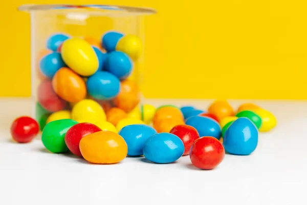 Botellas con dulces caramelos en la mesa foto creativa . —  Fotos de Stock