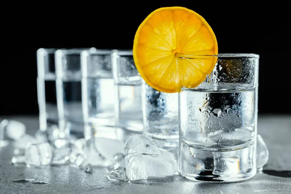 Kall vodka i shotglasögon på en svart bakgrund. — Stockfoto
