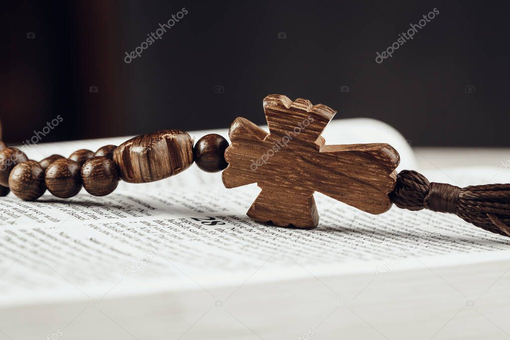 Bible and a crucifix on an old wooden table. Religion concept.