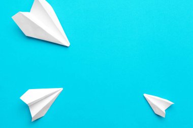 Mavi arka planda beyaz kağıt uçak