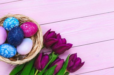 Yuvadaki Paskalya yumurtaları ve tahtadan yapılmış laleler.