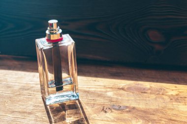 Ahşap arka planda parfüm şişeleri püskürtücü