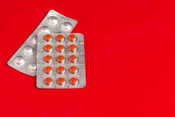 Conjunto médico de tabletas sobre fondo rojo. Pastillas — Foto de Stock