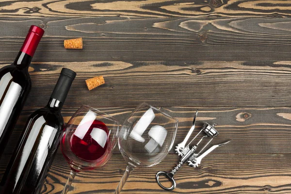 Bottle of wine and cork and corkscrew on wooden table — Stock Photo, Image