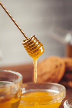 Tahta zemin üzerinde limon ve bal olan bir fincan çay..