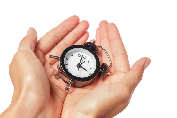 Mano femenina sosteniendo reloj despertador sobre fondo blanco. De cerca. . —  Fotos de Stock