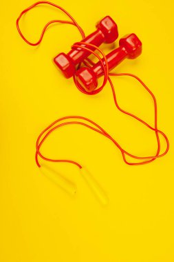 Parlak sarı arka planda fitness dambılları. Fitness konsepti