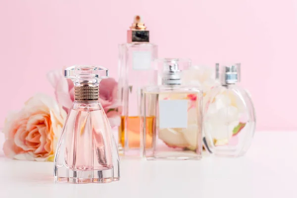 Bottle of perfume with flowers on color background — Stock Photo, Image