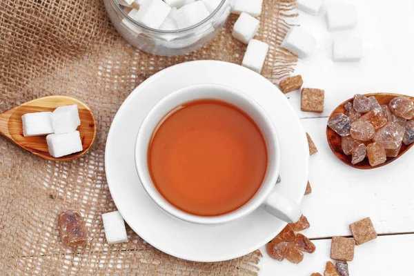 Xícara de vidro de chá quente com açúcar na mesa — Fotografia de Stock