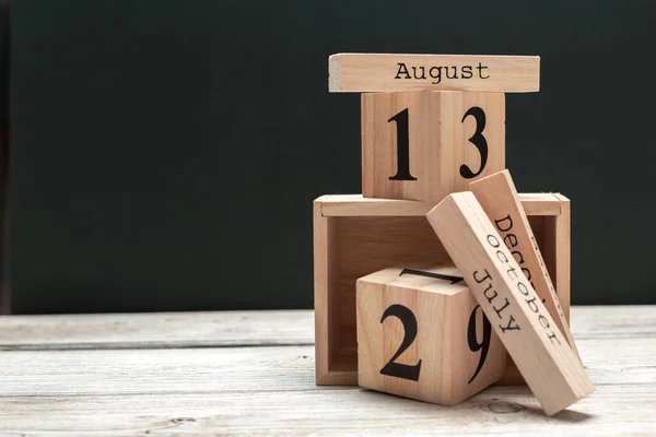 Zijaanzicht van delen van houten kalender op donker houten tafelblad — Stockfoto