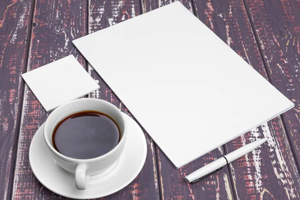 Schreibwarenattrappe auf lila Schreibtisch. Draufsicht auf Papier, Visitenkarte, Block, Stifte und Kaffee. — Stockfoto