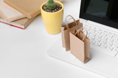 İnternetten alışveriş konsepti. Alışveriş arabası, dizüstü bilgisayar masanın üstünde.