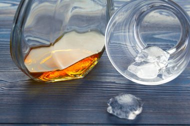 Bir bardak buzlu viski, bir şişe de ahşap çubukta.