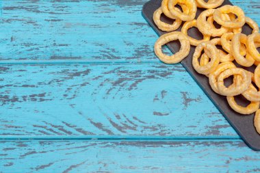 Ahşap zemin üzerinde gevrek soğan halkaları yığını