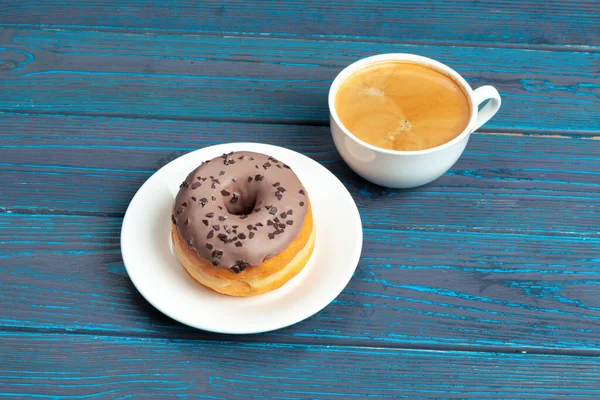 Frischer Donut mit Kaffee auf Holzoberfläche, Draufsicht — Stockfoto