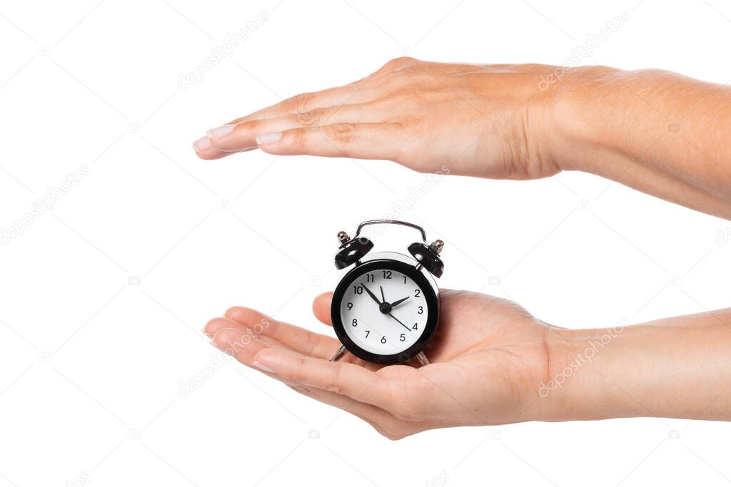 Female hand holding alarm clock on white background