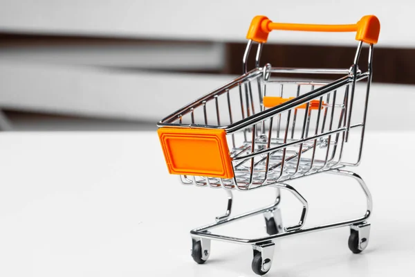 Carrito de compras de juguete vacío en una mesa — Foto de Stock