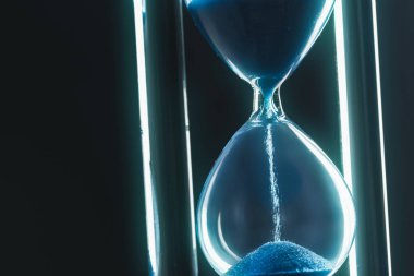 Kum saati koyu arkaplanda. Makro fotoğraf. Kapat..