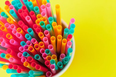 Renkli arka planda meşrubat için renkli pipetler