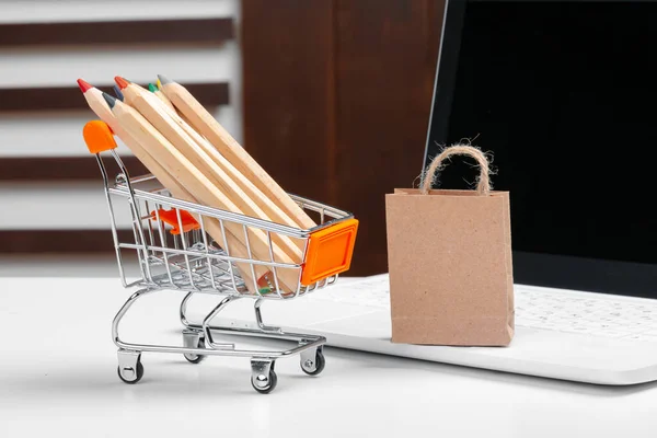 Online vásárlási koncepció. Bevásárlókocsi, laptop az asztalon — Stock Fotó