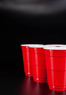 Bira oyunu için kırmızı plastik bardaklar ve top.