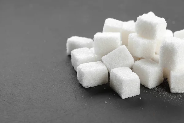 Cubos de açúcar branco sobre fundo preto fechar — Fotografia de Stock