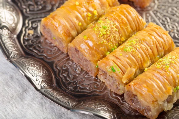 Турецкие сладости пахлава и металлический восточный поднос на деревянном фоне — стоковое фото