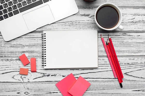 Mesa de escritório com bloco de notas em branco, laptop e material de escritório vista superior — Fotografia de Stock