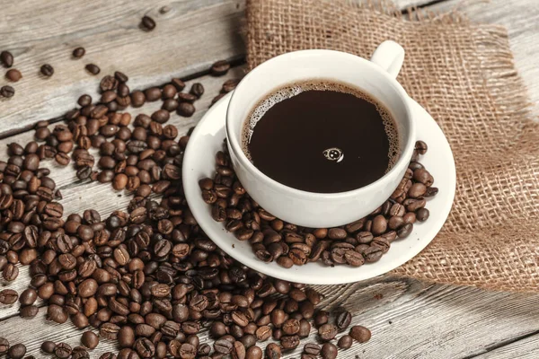 Tasse de café avec des grains sur la table — Photo