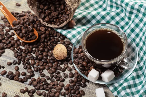 Taza de café y granos de café en la mesa. —  Fotos de Stock