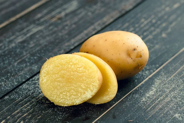 Fresh potatoes on the wood background. Close up. — Stock Photo, Image