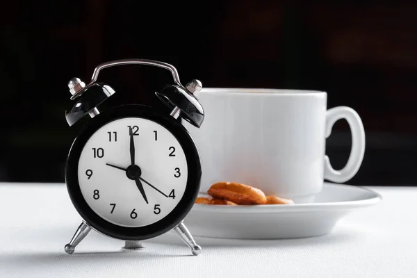 Csendélet, vintage ébresztőóra és kávéscsésze fehér asztalon — Stock Fotó