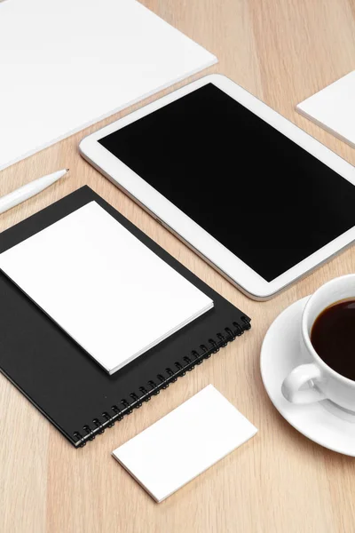 Tableta digital con bloc de notas, suministros y taza de café en el escritorio . — Foto de Stock