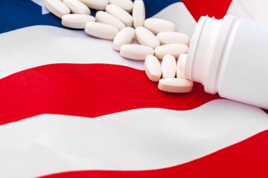 White prescription pills on United States flag clipart