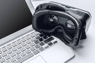 VR gözlükleri ve dizüstü bilgisayarı masada.