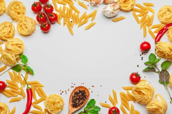 Pasta Spaghetti met ingrediënten voor het koken van pasta op een witte achtergrond, bovenaanzicht. — Stockfoto