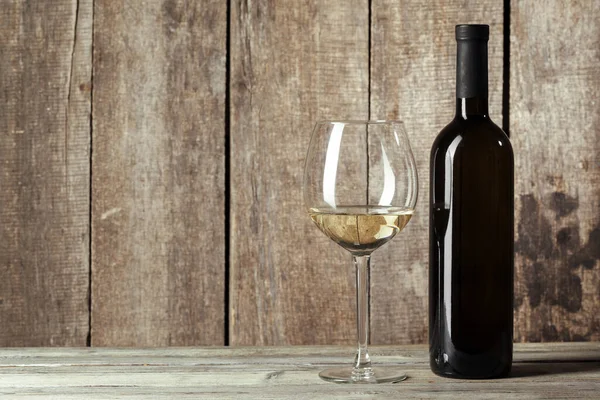Bouteilles de vin avec verre, fond bois. Gros plan . — Photo