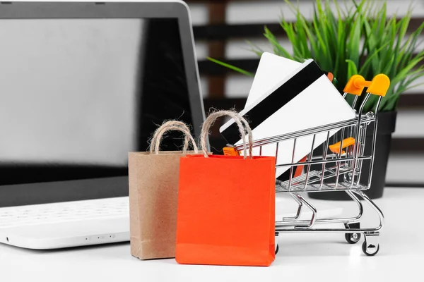 Conceito de compras online. Carrinho de compras, laptop na mesa — Fotografia de Stock