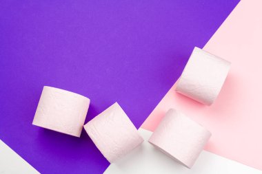 Parlak renk bloğu arka planında Pastel pembe tuvalet kağıdı