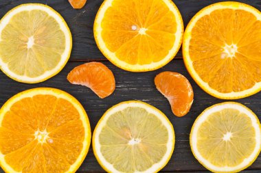 Siyah ahşap bir arka planda turunçgil meyveleri dilimi