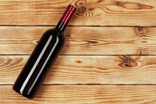 Бутылка вина на деревянном фоне. Закрыть . — стоковое фото