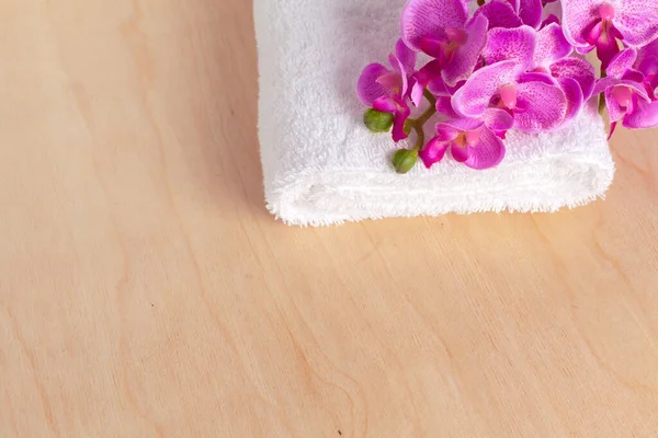 Toallas suaves limpias con flor en la mesa de madera — Foto de Stock