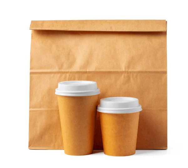 Bolsa de papel artesanal y café para llevar tazas sobre fondo blanco —  Fotos de Stock