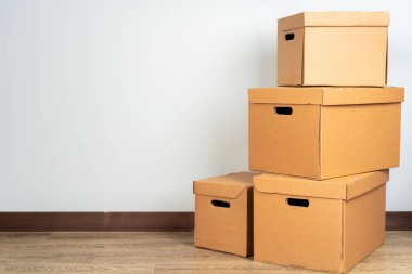 Tahta zeminde kahverengi karton kutular var.