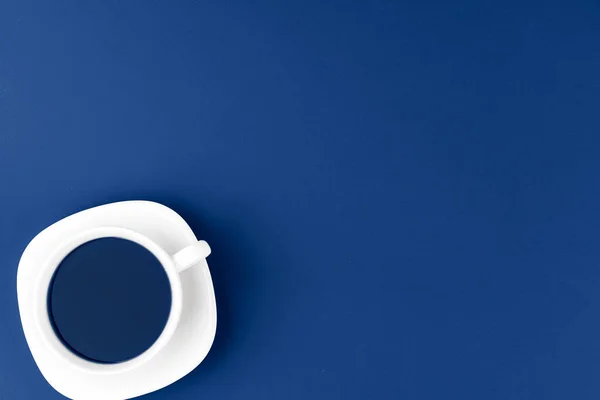 Vue du dessus d'une tasse de café sur soucoupe sur fond bleu classique — Photo