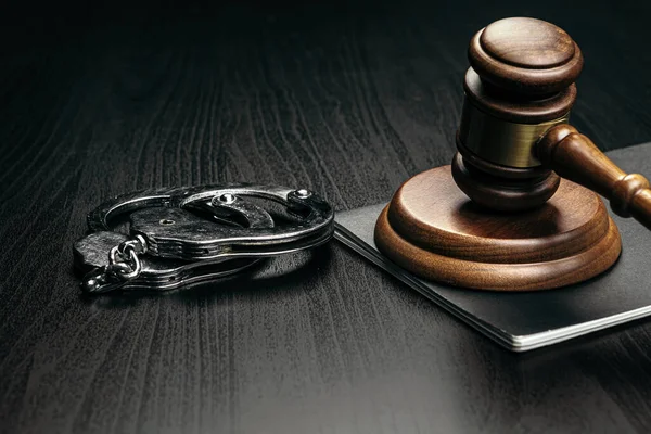 Judge gavel with handcuffs on wooden table — Stock Photo, Image