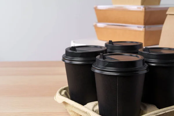 Muitos vários recipientes de comida take-out, caixa de pizza, xícaras de café e sacos de papel no fundo cinza claro — Fotografia de Stock