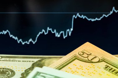 Fiyat tablosu olan bir monitörün önünde dolar. Eski ve ticaret.