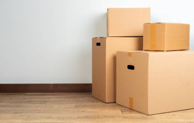 Tahta zeminde kahverengi karton kutular var.