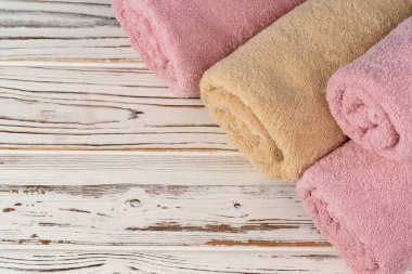 Tahta bir masada rulo havlu yığını.